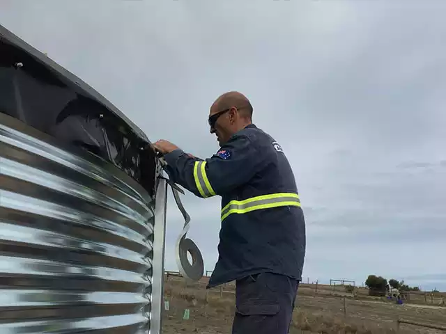 Man working on a corrugated tank
