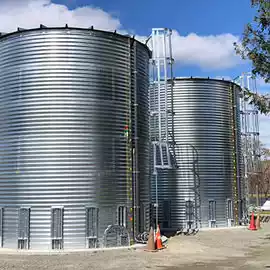 Two large corrugated steel tanks with ladders