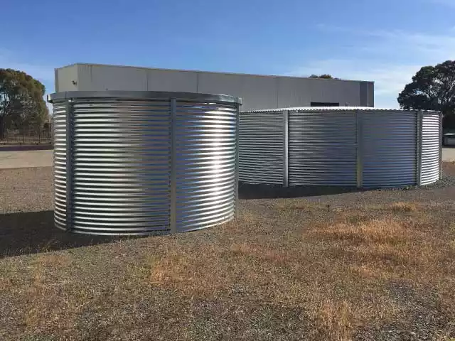 Large corrugated steel water storage tank installed in an outdoor setting