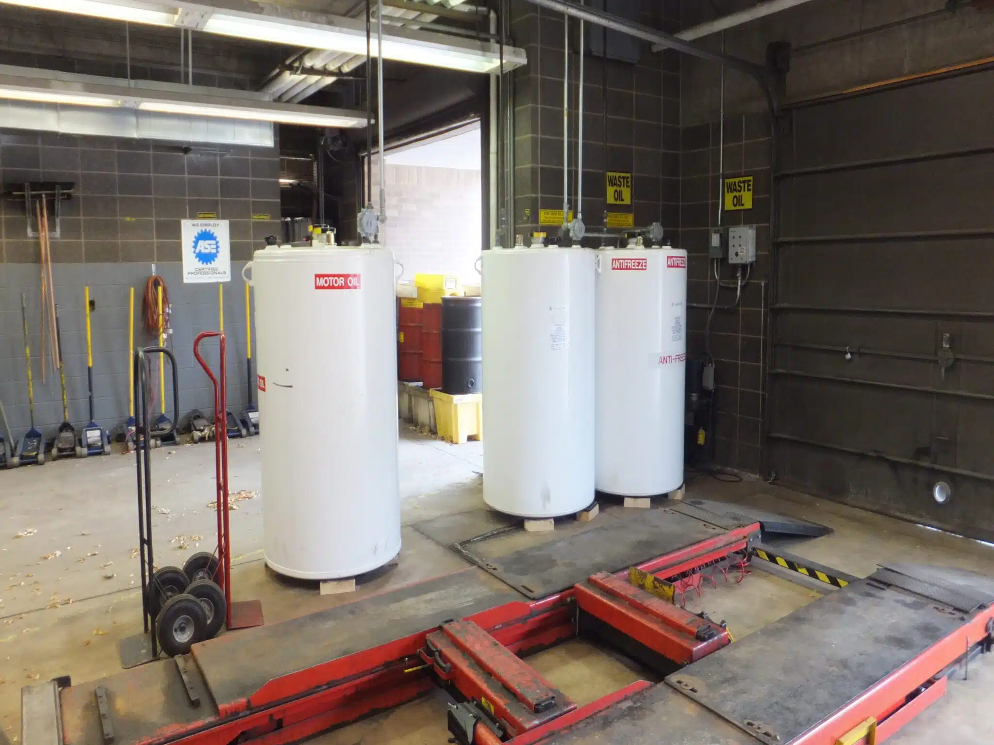 Three vertical aboveground steel storage tanks installed inside a maintenance facility.